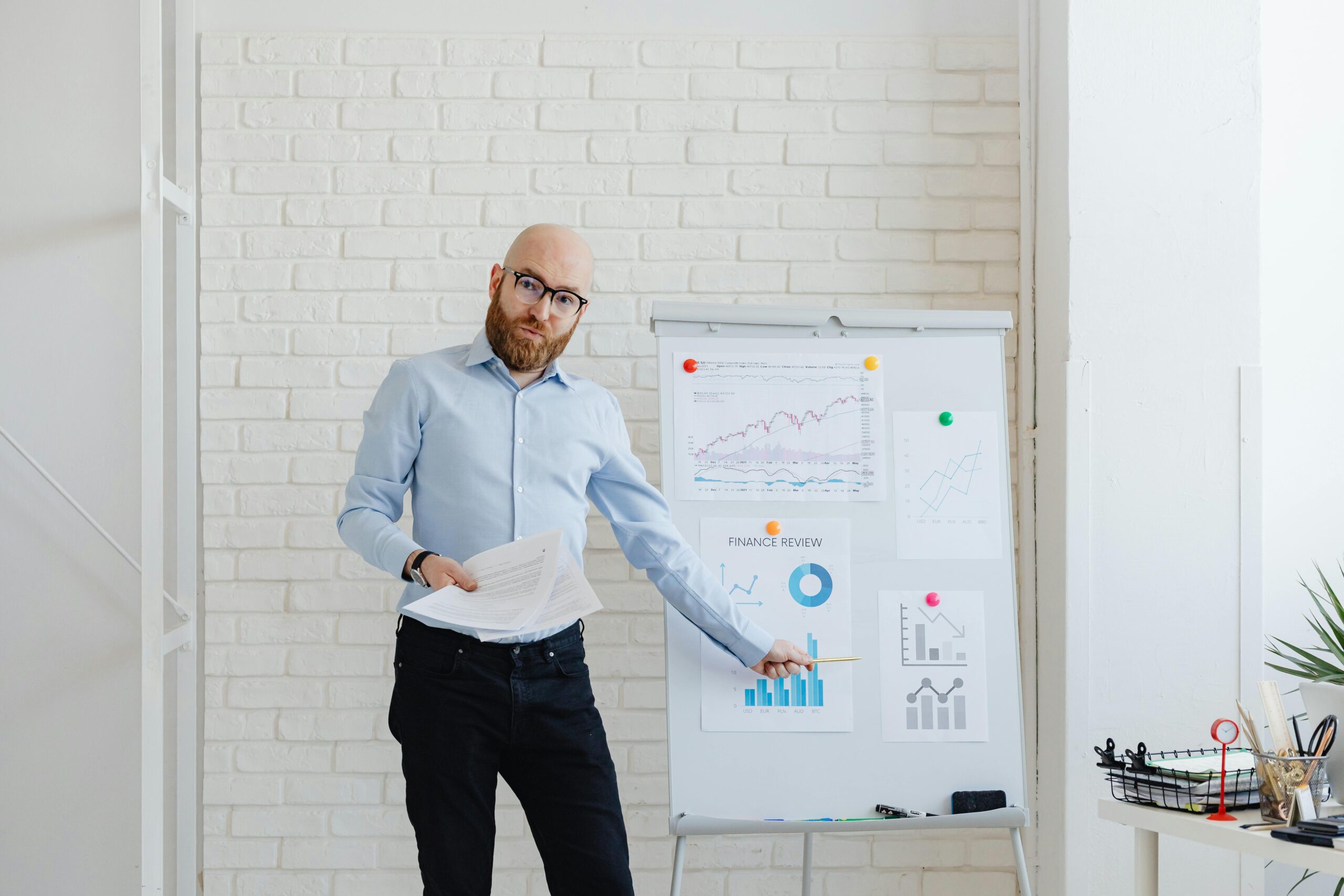 Businessman explaining charts and graphs during a financial presentation in modern office.
